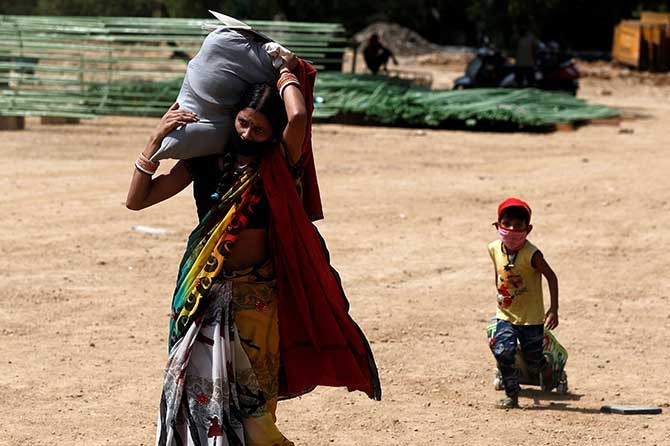 A lady with her son rush to take a bus in Mumbai to take them to their home state of Uttar Pradesh. Photograph: Francis Mascarenhas/Reuters